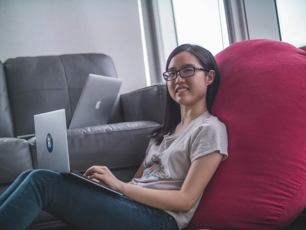 a female student wearing glasses using a laptop