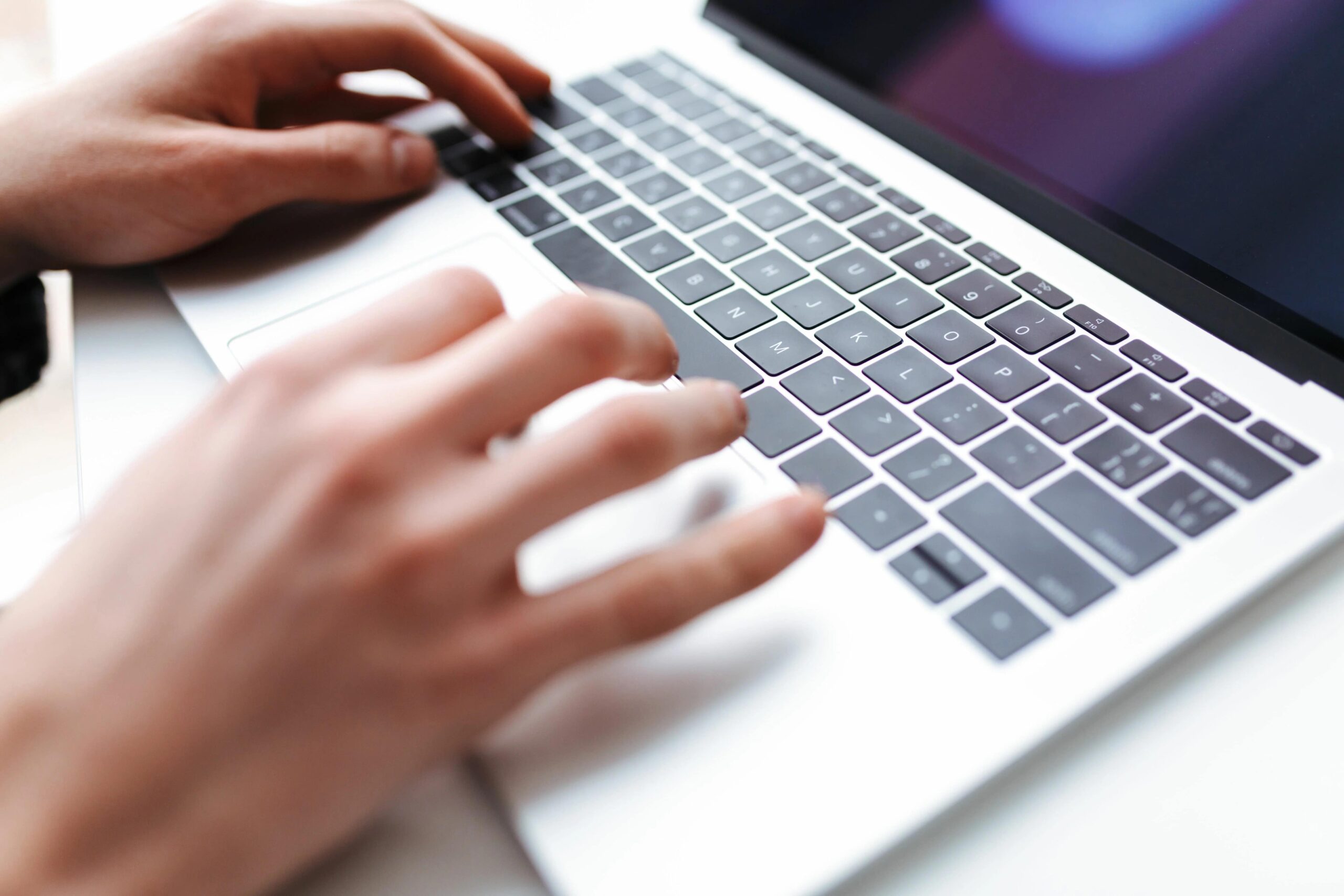 a close up image of a pair of hand using a laptop