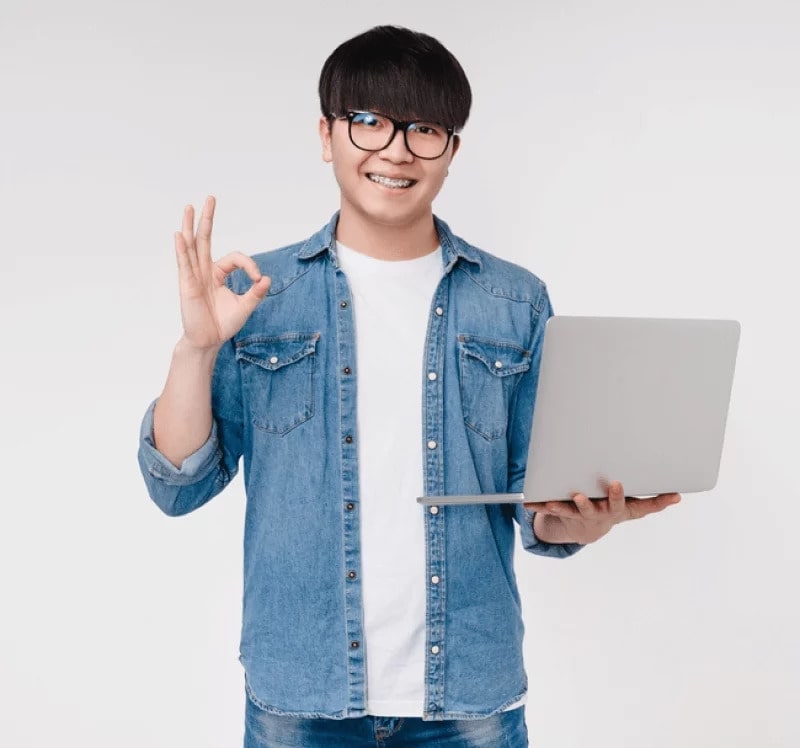 a male student happily holding a laptop