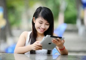 a girl happily using an electronic tablet