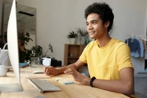 a happily studying in front of a computer