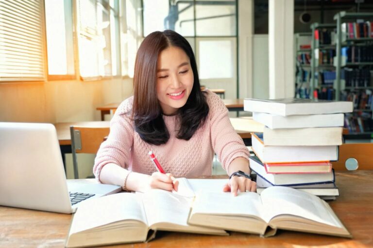 a female student happily studying in a library