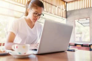 a girl wearing glasses using a laptop